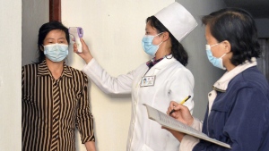 FILE - In this photo provided by the North Korean government, a doctor checks a resident's temperature to curb the spread of coronavirus infection, in Pyongyang, North Korea on May 17, 2022. North Korea said Friday, May 20, that nearly 10% of its 26 million people have fallen ill and 65 people have died amid its first COVID-19 outbreak, as outside experts question the validity of its reported fatalities and worry about a possible humanitarian crisis. Independent journalists were not given access to cover the event depicted in this image distributed by the North Korean government. The content of this image is as provided and cannot be independently verified. (Korean Central News Agency/Korea News Service via AP, File)