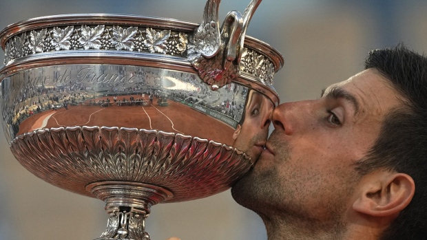 FILE - Serbia's Novak Djokovic kisses the cup after defeating Stefanos Tsitsipas of Greece during their final match of the French Open tennis tournament at the Roland Garros stadium, Sunday, June 13, 2021 in Paris. Djokovic won 6-7 (6), 2-6, 6-3, 6-2, 6-4. Rafael Nadal and Novak Djokovic are both entered in the French Open, making it the first Grand Slam tournament with both of them in the field since last year’s French Open. (AP Photo/Michel Euler, File)