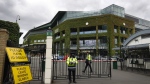 FILE - Security guards are shown at the gate in front of Centre Court at the All England Lawn Tennis Club, after the 2020 tennis championships were canceled due to the coronavirus, in Wimbledon, London, Monday, June 29, 2020. The ATP men’s professional tennis tour will not award ranking points for Wimbledon this year because of the All England Club’s ban on players from Russia and Belarus over the invasion of Ukraine. The ATP announced its decision Friday night, May 20, 2022, two days before the start of the French Open — and a little more than a month before play begins at Wimbledon on June 27. It is a highly unusual and significant rebuke of the oldest Grand Slam tournament. (AP Photo/Kirsty Wigglesworth, File)