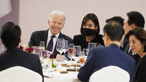 U.S. President Joe Biden, back left, shares a light moment with people at a table with South Korean President Yoon Suk Yeol, back right, at a state dinner at the National Museum of Korea, Saturday, May 21, 2022, in Seoul. (AP Photo/Evan Vucci)