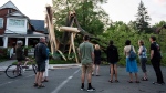 Community members gather to look at a tree that was destroyed during a major storm in Ottawa on Saturday, May 21, 2022. THE CANADIAN PRESS/Justin Tang