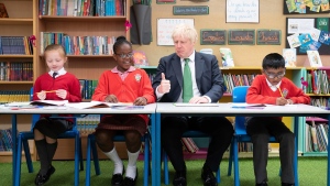 British Prime Minister Boris Johnson sits beside pupils as he pays a visit to St Mary Cray Primary Academy, in Orpington, England, Monday May 23, 2022 to see how they are delivering tutoring to help children catch up following the pandemic. (Stefan Rousseau, Pool via AP)