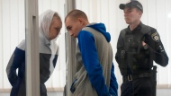 Russian Sgt. Vadim Shishimarin listens to his translator during a court hearing in Kyiv, Ukraine, Monday, May 23, 2022. The 21 year old soldier facing the first war crimes trial since the start of the war in Ukraine plead guilty on May 18 to killing an unarmed civilian. (AP Photo/Natacha Pisarenko)