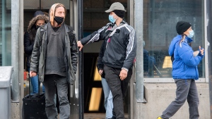 People wear face masks as they leave a metro station in Montreal, Saturday, March 12, 2022, as the COVID-19 pandemic continues in Canada. THE CANADIAN PRESS/Graham Hughes
