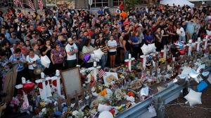 People crowd around a makeshift memorial at the scene of a mass shooting at a shopping complex, Tuesday, Aug. 6, 2019, in El Paso, Texas. (AP Photo/John Locher)
