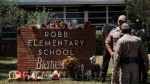 Flowers and candles are placed outside Robb Elementary School in Uvalde, Texas, Wednesday, May 25, 2022, to honor the victims killed in Tuesday's shooting at the school. Desperation turned to heart-wrenching sorrow for families of grade schoolers killed after an 18-year-old gunman barricaded himself in their Texas classroom and began shooting, killing several fourth-graders and their teachers. (AP Photo/Jae C. Hong)