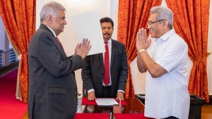 In this handout photograph provided by the Sri Lankan President's Office, President Gotabaya Rajapaksa, right, greets prime minister Ranil Wickremesinghe during the latter's oath taking ceremony as the new finance minister in Colombo, Sri Lanka, Wednesday, May 25, 2022. (Sri Lankan President's Office via AP)