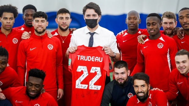 Prime Minister Justin Trudeau, centre, poses with Team Canada soccer players in Edmonton, Alta., Monday, Nov. 15, 2021.THE CANADIAN PRESS/Jeff McIntosh