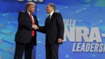FILE - President Donald Trump shakes hands with NRA executive vice president and CEO Wayne LaPierre, has he arrives to speak to the annual meeting of the National Rifle Association, Friday, April 26, 2019, in Indianapolis. The National Rifle Association is going ahead with its annual meeting in Houston just days after the shooting massacre at a Texas elementary school that left 19 children and 2 teachers dead. With protests planned outside, former President Donald Trump and other leading GOP figures, including South Dakota Gov. Kristi Noem, will address attendees. (AP Photo/Evan Vucci, File)