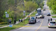 Police and investigators are seen at the scene of a shooting in Toronto, Thursday, May 26, 2022. Toronto police say a man has died after an interaction with officers during which a police gun was fired. THE CANADIAN PRESS/Aaron Vincent Elkaim
