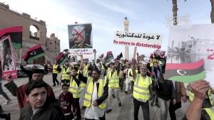 FILE - Protesters wear yellow vests at a protest as they wave national flags and chant slogans against Libya's Field Marshal Khalifa Hifter, in Tripoli, Libya on April 19, 2019. Libya faces a serious security threat from foreign fighters and private military companies, especially Russia’s Wagner Group which has violated international law, U.N. experts said in a report obtained Friday, May 27, 2022 by The Associated Press. (AP Photo/Hazem Ahmed, File)