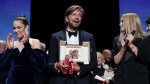 Writer/director Ruben Ostlund, center, accepts the Palme d'Or for 'Triangle of Sadness' as jury member Noomi Rapace, left, and Virginie Efira look on during the awards ceremony of the 75th international film festival, Cannes, southern France, Saturday, May 28, 2022. (Photo by Joel C Ryan/Invision/AP)