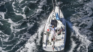 Japan's Kenichi Horie waves on his sailing boat after his trans-Pacific voyage, at Osaka Bay, western Japan, Saturday, June 4, 2022. The 83-year-old Japanese adventurer returned home Saturday after successfully completing his solo, nonstop voyage across the Pacific, becoming the oldest person to reach the milestone.(Kyodo News via AP)