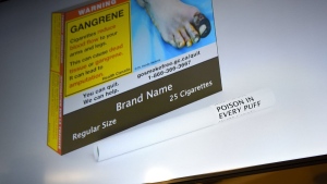 An example of cigarette packaging with expanded warnings, including a warning printed on the cigarettes themselves, is shown on a screen after a news conference on expanded regulations for tobacco products, in Ottawa, on Friday, June 10, 2022. THE CANADIAN PRESS/Justin Tang