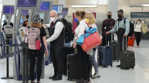 People wait in line to check in at Pearson International Airport in Toronto on Thursday, May 12, 2022. The federal government is putting an end to COVID-19 vaccine mandates for domestic and outbound international travellers and public sector workers. THE CANADIAN PRESS/Nathan Denette