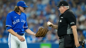 Toronto Blue Jays starting pitcher Kevin Gausman (34) was having issues with a few baseballs and talks with home plate umpire Paul Emmel during first inning American League baseball action in Toronto on Thursday, June 16, 2022. THE CANADIAN PRESS/Nathan Denette