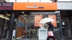 A woman walks past a Freedom Mobile store in Toronto, Thursday, Nov. 24, 2016. Rogers Communications Inc. says it will sell Freedom Mobile Inc. to Quebecor Inc. for $2.85 billion in a deal it hopes will appease the concerns of federal regulators about its proposed takeover of Shaw Communications. THE CANADIAN PRESS/Nathan Denette