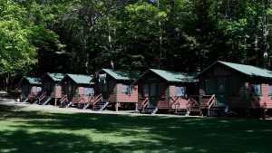 FILE - This Thursday, June 4, 2020 file photo shows a row of cabins at a summer camp in Fayette, Maine. (AP Photo/Robert F. Bukaty, File) 