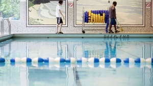 A person sweeps the pool deck in Toronto on Friday, August 10, 2012. THE CANADIAN PRESS/Michelle Siu 