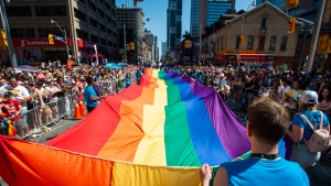 FILE - Volunteers with Pride Toronto carry a large rainbow flag during the 2019 Pride Parade in Toronto, Sunday, June 23, 2019. THE CANADIAN PRESS/Andrew Lahodynskyj 