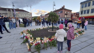 FILE - People gather around flowers and candles after a man killed several people on Wednesday afternoon, in Kongsberg, Norway, Thursday, Oct. 14, 2021. A man was Friday, June 24, 2022 found guilty to murder and attempted murder for fatally stabbing five and wounding four others in southern Norway when he attacked strangers with a bow and arrows and knives. (AP Photo/Pal Nordseth, File)