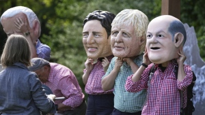 Activists from Oxfam wear giant heads depicting G7 leaders during a demonstration in Munich, Germany, Saturday, June 25, 2022. The G7 Summit will take place at Castle Elmau near Garmisch-Partenkirchen from June 26 through June 28, 2022. Leaders depicted from left, U.S. President Joe Biden, Canada's Prime Minister Justin Trudeau, British Prime Minister Boris Johnson and German Chancellor Olaf Scholz. (AP Photo/Matthias Schrader)