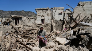 Afghan man carries his child amid destruction after an earthquake in Gayan village, in Paktika province, Afghanistan, Friday June 24, 2022. A powerful earthquake struck a rugged, mountainous region of eastern Afghanistan early Wednesday, flattening stone and mud-brick homes in the country's deadliest quake in two decades, the state-run news agency reported. (AP Photo/Ebrahim Nooroozi)