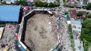 In this image taken from video, spectators are sent plunging to the ground as part of a wooden stand collapses during a bullfight, Sunday, June 26, 2022, at a stadium in the city of El Espinal in Tolima state, central Colombia. (AP Video)