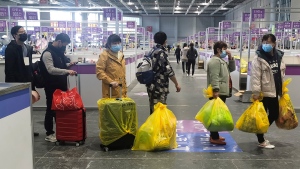 People who have been negative in the last two nucleic acid tests line up to leave a temporary hospital converted from the National Exhibition and Convention Center to quarantine COVID-positive people in Shanghai, China on April 18, 2022. (Chinatopix via AP)
