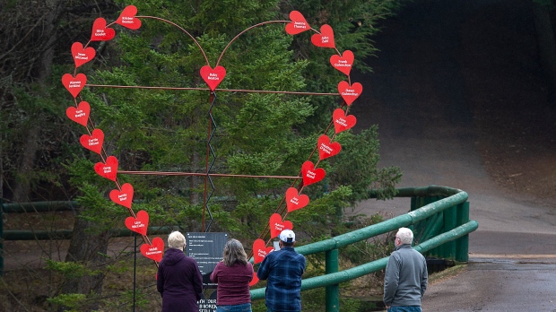 Visitors pay their repects at a memorial honouring the victims of the April 2020 murder rampage in rural Nova Scotia, in Victoria Park in Truro, N.S. on Tuesday, April 13, 2021.  THE CANADIAN PRESS/Andrew Vaughan 