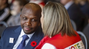 Former Olympian Donovan Bailey, left, speaks to a fan during a rally in support of the 2026 Winter Olympic bid in Calgary, Alta., Monday, Nov. 5, 2018. Bailey is among the dozens of performers, athletes, advocates and experts newly named to the Order of Canada on Wednesday. THE CANADIAN PRESS/Jeff McIntosh