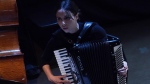 Erica Mancini plays her accordion during a Ukrainian avant garde jazz opera, Friday, June 17, 2022, at Bohemian National Hall in New York. Mancini has suffered three COVID-19 infections: one at the beginning of the pandemic, one last year and one in May of this year. Medical experts warn that we'll be seeing more multiple reinfections given how long the pandemic is stretching on. (AP Photo/Bebeto Matthews)