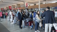 Passengers lineup at the check in counter at Pierre Elliott Trudeau airport, in Montreal, Wednesday, June 29, 2022. An analytics firm says a majority of domestic flights to some of Canada's busiest airports were delayed or cancelled over the past week. THE CANADIAN PRESS/Ryan Remiorz