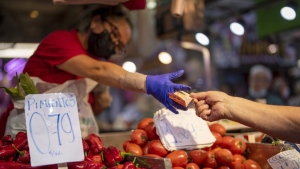 FILE - A customer pays for vegetables at the Maravillas market in Madrid, on May 12, 2022. Inflation figures for Europe will be released Friday, July 1, 2022, as Russia's war in Ukraine has worsened the worldwide surge in consumer prices. For months, inflation in the 19 countries that use the euro has risen at the fastest pace since record-keeping for the currency began. (AP Photo/Manu Fernandez, File)