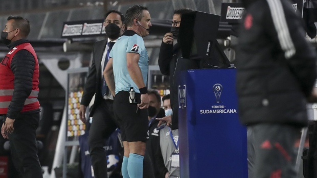 Referee Patricio Loustau of Argentina checks the VAR during a Copa Sudamericana soccer match between Chile's Colo Colo and Brazil's Internacional in Santiago, Chile, Tuesday, June 28, 2022. (AP Photo/Luis Hidalgo)