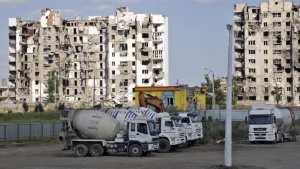 Cement trucks parked at a construction site of an apartment building under construction for residents of Mariupol affected by hostilities, in Mariupol, in territory under the government of the Donetsk People's Republic, eastern Ukraine, Friday, July 1, 2022. (AP Photo)