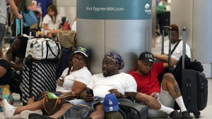 Alisson Bryan, Marcel Bryan and Terry Craig, wait to check-in their luggage for their flight home to Missouri at Miami International Airport, Saturday, July 2, 2022, in Miami. The group were on a cruise ship vacation in the Caribbean. The Fourth of July holiday weekend is jamming U.S. airports with the biggest crowds since the pandemic began in 2020. (AP Photo/Marta Lavandier)