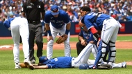 Toronto Blue Jays' Kevin Gausman, centre, is checked on after being hit by a batted ball off the bat of a Tampa Bay Rays batter in second inning American League baseball action in Toronto, Saturday, July 2, 2022. Gausman would leave the game. THE CANADIAN PRESS/Jon Blacker