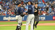 Tampa Bay Rays relief pitcher Ralph Garza Jr, right, and catcher Francisco Mejia celebrate their team's victory over the Toronto Blue Jays in the second game of doubleheader American League baseball action in Toronto, Saturday, July 2, 2022. THE CANADIAN PRESS/Jon Blacker 
