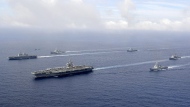 FILE - In this photo provided by South Korea's Defense Ministry, U.S. nuclear-powered aircraft carrier USS Ronald Reagan, second from left, and South Korea's landing platform helicopter (LPH) ship Marado, left, sail during a joint military exercise at an undisclosed location, June 4, 2022. (South Korea Defense Ministry via AP, File)