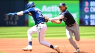 Toronto Blue Jays' Teoscar Hernandez is tagged out in a rundown by Tampa Bay Raysâ€™ Taylor Walls a Tampa Bay Rays in first inning American League baseball action in Toronto, Sunday, July 3, 2022. THE CANADIAN PRESS/Jon Blacker 