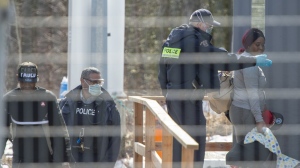 Asylum seekers cross the border from New York into Canada at Roxham Road Wednesday, March 18, 2020, in Hemmingford, Quebec. THE CANADIAN PRESS/Ryan Remiorz