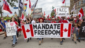 People protest and march on Wellington street against COVID-19 health measures during Canada Day in Ottawa, Ontario, on Friday July 1, 2022. THE CANADIAN PRESS/Lars Hagberg