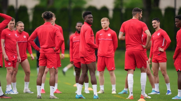 Canadian national men's soccer team forward Alphonso Davies, centre, stands with his teammates during a training session for a CONCACAF Nations League match against Curacao, in Vancouver, on June 7, 2022. Canada Soccer says it has made a new compensation offer to its men's and women's national teams. THE CANADIAN PRESS/Darryl Dyck