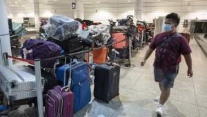 A passenger looks for his luggage among a pile of unclaimed baggage at Pierre Elliott Trudeau airport, in Montreal, Wednesday, June 29, 2022. There's one prevailing piece of advice when it comes to managing air travel in 2022: "pack your patience." But from booking a flight to landing at your destination, industry insiders are sharing some pro tips to make the process as smooth as possible. THE CANADIAN PRESS/Ryan Remiorz