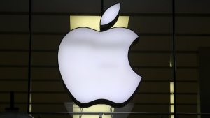 The logo of Apple is illuminated at a store in the city center in Munich, Germany, Wednesday, Dec. 16, 2020. After the U.S. Supreme Court revoked the federal right to an abortion that's been in place for half a century, companies like Amazon, Disney, Apple and JP Morgan pledged to cover travel costs for employees who live in states where the procedure is now illegal so they can terminate pregnancies. (AP Photo/Matthias Schrader)
