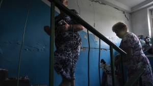 64-year-old Tetiana Solohub, left, walks up with her friend to see her apartment destroyed from Russian aerial bombs, in Borodyanka, Kyiv region, Ukraine, Tuesday, June 28, 2022. "And now, at 64, I am forced to be homeless," Solohub said. She doesn't have a damaged apartment to live in. Hers is completely gone. Solohub now lives in a camp made of shipping containers. (AP Photo/Nariman El-Mofty)