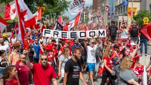 People protest and march on Wellington street against COVID-19 health measures during Canada Day in Ottawa, Ontario, on Friday July 1, 2022. THE CANADIAN PRESS/Lars Hagberg 