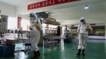 Health officials of the Pyongyang Sports Goods Factory disinfect the floor of a work place in Pyongyang, North Korea on June 14, 2022. The red banner says "Economy means increased production and patriotism." Only a month after North Korea acknowledged a COVID-19 outbreak was sickening its people, the country may be preparing to declare victory. The daily updates from state-controlled media say cases are plummeting. Its propaganda insists North Korea has avoided mass deaths despite desperately poor health care and what outsiders see as a long record of ignoring its people's suffering. (AP Photo/Cha Song Ho, File)