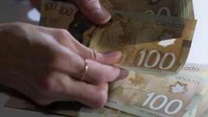 Canadian $100 bills are counted in Toronto, Feb. 2, 2016. New research paints a sombre outlook for Canadian household finances as inflation takes a bite out of real wages and rising interest rates mute economic growth. THE CANADIAN PRESS/Graeme Roy